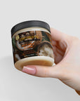 Jar of raw shea butter held in hand, showcasing cream texture and natural, vegan-friendly skincare benefits.