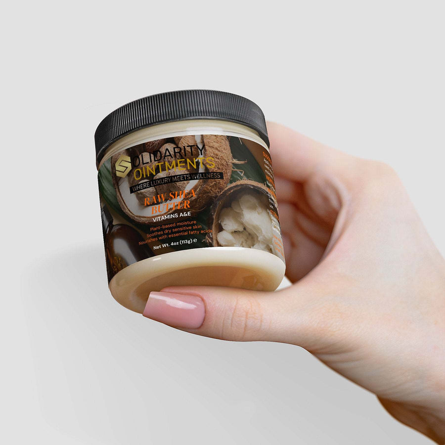 Jar of raw shea butter held in hand, showcasing cream texture and natural, vegan-friendly skincare benefits.