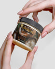 Organic raw shea butter jar held by hands, 4 oz, vegan, cruelty-free, deeply moisturizing.