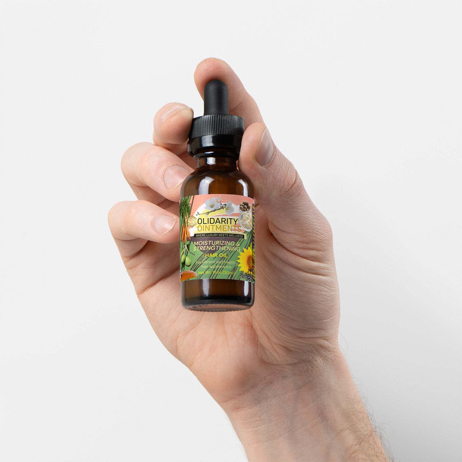 Moisturizing and Strengthening Hair Oil bottle held in hand