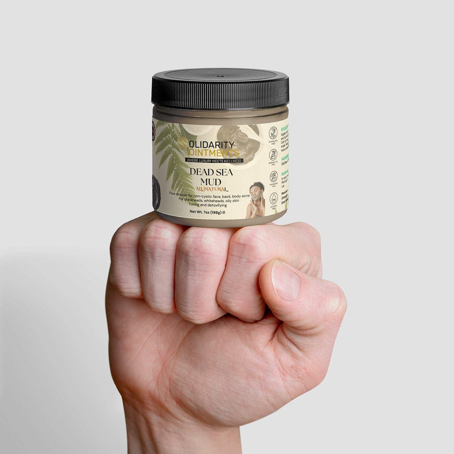 Dead Sea Mud jar held in a hand, showcasing natural skincare benefits.