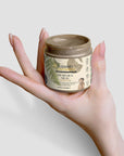 Dead Sea mud jar held in hand, natural skincare product, mineral-rich formula, spa-quality experience.