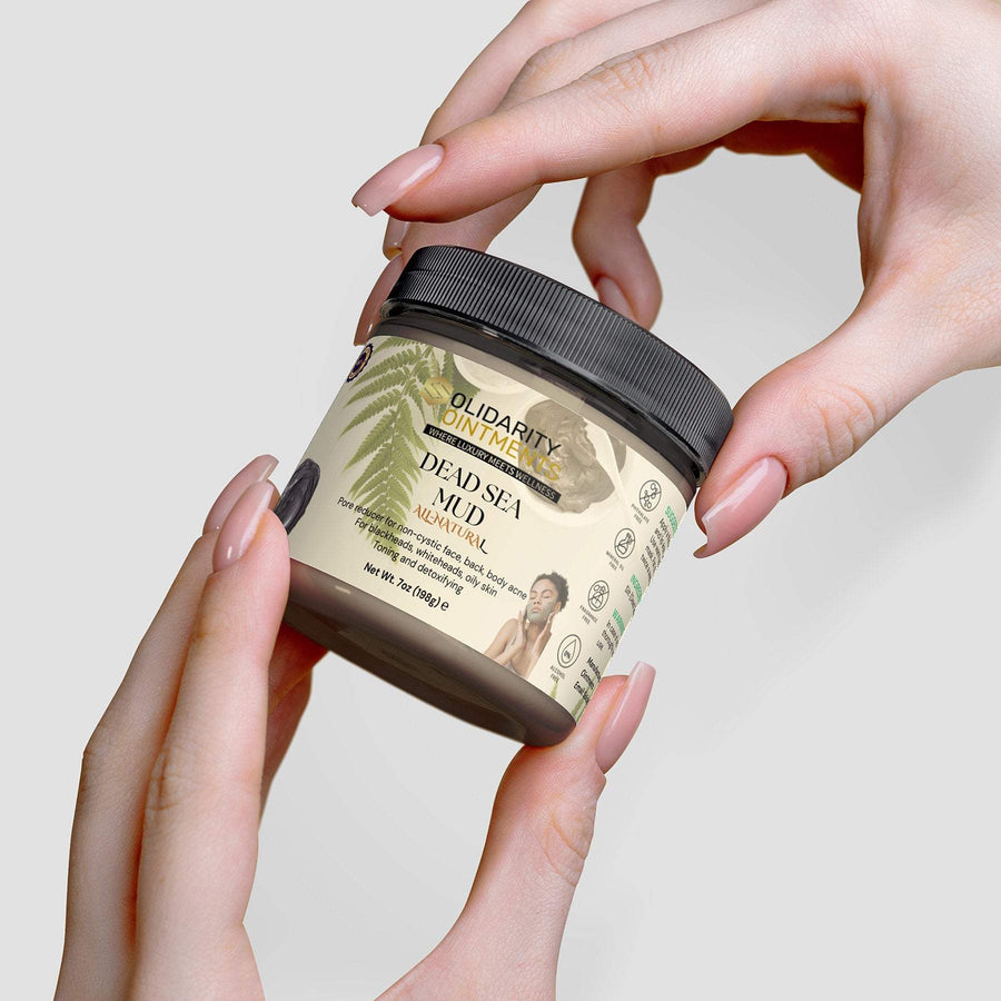 Dead Sea Mud jar held in hands for natural skincare rejuvenation.