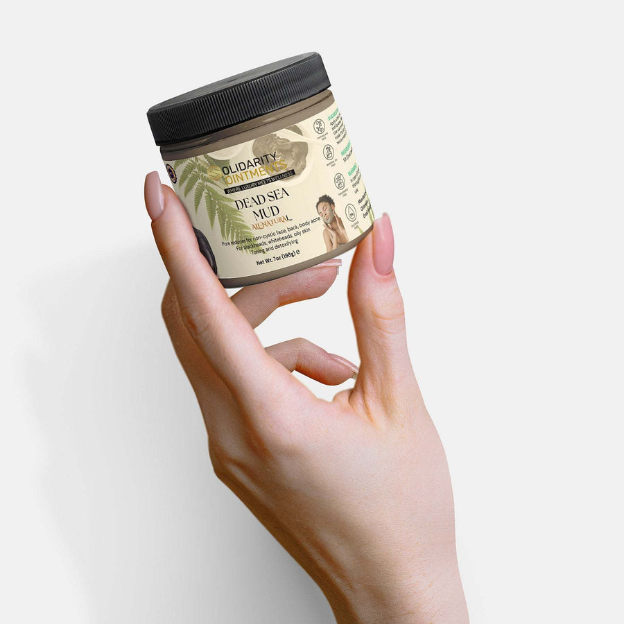 Dead Sea Mud jar held in hand, mineral-rich skincare remedy for rejuvenation and pore reduction.