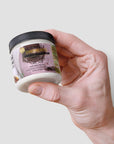 Recovery cream jar held in hand, premium skincare with aloe and essential oils for moisturizing and hydration.